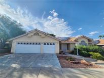 Charming single-story home with a three-car garage, well-maintained landscaping and a light-colored exterior at 8220 Desert Beach Dr, Las Vegas, NV 89128