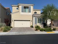 Charming two-story home featuring a neutral color palette, well-kept landscaping, and a brick driveway at 1012 Via Stellato St, Henderson, NV 89011
