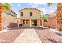 Spacious backyard featuring a covered patio and a low-maintenance desert landscape with palm trees at 11755 Garland Grove Ln, Las Vegas, NV 89183
