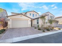 Beautiful home featuring a paver driveway and two-car garage, complemented by manicured landscaping at 19 Cresta Villa Ct, Henderson, NV 89011