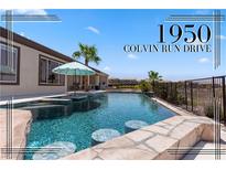 An inviting backyard pool features a swim-up bar, cool blue water, and patio umbrella for relaxing shade at 1950 Colvin Run Dr, Henderson, NV 89052