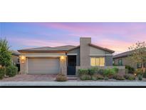 Charming single-story home featuring manicured landscaping and a neutral color palette at sunset at 2069 Alto Vista Dr, Henderson, NV 89052