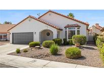 Charming single-story home featuring a well-manicured front yard and a two-car garage at 4324 Peaceful Path Ct, North Las Vegas, NV 89032