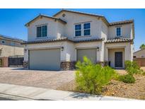 Inviting two-story home featuring a two-car garage and charming desert landscaping at 5660 Oasis Ridge St, North Las Vegas, NV 89031