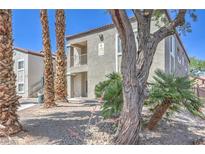 Exterior view showcasing the building's facade with landscaping, trees, and visible unit numbers at 6160 Rumrill St # 215, Las Vegas, NV 89113