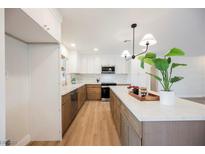 Bright kitchen with a large island, stainless steel appliances, two-tone cabinets, and modern lighting at 617 6Th St, Boulder City, NV 89005