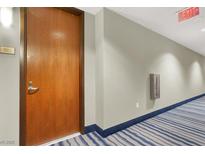 Hallway with an exit sign and a blue striped carpet near the door to unit 722 at 8255 Las Vegas Blvd # 722, Las Vegas, NV 89123