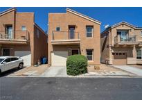 Two-story home with tan stucco, balcony, and front yard landscaping at 9443 Hot Breeze St, Las Vegas, NV 89178