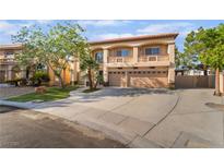 Two-story home with a neutral color palette, balcony, three-car garage, and a well-manicured lawn at 1403 Graystone Canyon Ave, Las Vegas, NV 89183