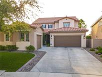 Charming two-story home features a tile roof, well-manicured lawn, and a spacious driveway at 1513 Ravanusa Dr, Henderson, NV 89052