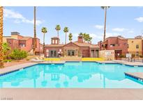 Community pool surrounded by lounge chairs and landscaping, perfect for relaxation at 4050 Pacific Harbors Dr # 127, Las Vegas, NV 89121