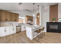 Bright kitchen boasts modern appliances, white countertops, stylish island with bar seating, and contrasting cabinets at 410 Aloha Dr, Henderson, NV 89015