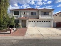 Charming two-story home featuring a three-car garage and a welcoming brick walkway to the front door at 577 Leap Frog Ave, Las Vegas, NV 89183