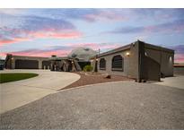 Unique home with a dome feature, covered area, and expansive driveway at dusk at 7215 Ullom Dr, Las Vegas, NV 89118
