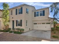 Charming two-story home featuring a brick driveway, attached two-car garage, and a well-manicured front yard at 8353 Lower Trailhead Ave, Las Vegas, NV 89113