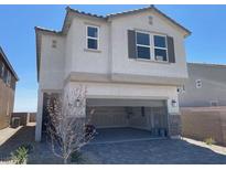 Two-story stucco home with a paved driveway leading to an open two-car garage and a desert-style landscaped yard at 9564 Hinson St, Las Vegas, NV 89102