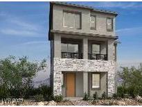 Modern three-story home featuring stone accents, a small balcony, and large windows at 1536 Little Penguin St, Las Vegas, NV 89138