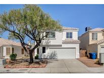 Charming two-story home features a well-manicured front yard and a classic stucco facade, creating a welcoming curb appeal at 1716 Klamath Falls Way, Las Vegas, NV 89128