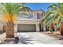 Charming two-story home with a tile roof, desert landscaping, and palm trees framing the front entrance and two-car garage at 6569 Cedar Waxwing St, North Las Vegas, NV 89084