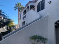 Condo exterior featuring stucco siding, a palm tree, and a private staircase to the upper level at 700 Carnegie St # 4821, Henderson, NV 89052