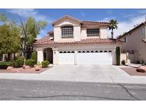 Inviting two-story home with a spacious three-car garage and well-maintained front yard at 1700 Double Arrow Pl, Las Vegas, NV 89128