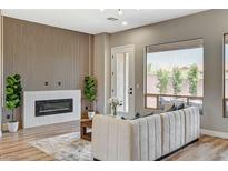Bright living room featuring fireplace, modern wall design, plush seating, and stylish decor at 3218 Squire St, Las Vegas, NV 89135