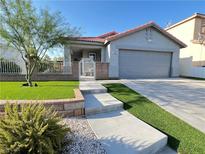 Charming single-story home featuring a two-car garage, a well manicured lawn and decorative brickwork at 6292 Yucca Valley Ct, Las Vegas, NV 89142