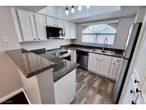 Well-lit kitchen featuring stainless steel appliances, granite countertops, and modern white cabinetry at 8455 W Sahara Ave # 213, Las Vegas, NV 89117