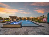 Stunning backyard with a large pool, spa, covered outdoor kitchen, and a spacious patio area, perfect for entertaining at 8528 Baltimore Heights Ct, Las Vegas, NV 89113