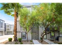 Two-story gray home with a well-manicured front yard with mature trees and a healthy green lawn at 9050 W Tropicana Ave # 1017, Las Vegas, NV 89147