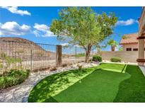 The backyard features a putting green with artificial turf and a desert landscape view at 96 Saint Johns Wood Ave, Henderson, NV 89002