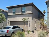 Two-story home featuring a neutral stucco exterior, two-car garage, and low-maintenance desert landscaping at 4056 Campeche Ave, Las Vegas, NV 89121