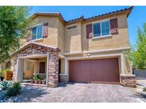 Charming two-story home featuring a stone-accented porch and a two-car garage with brick-paved driveway at 4206 Topaz Hills Dr, North Las Vegas, NV 89032