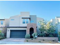Contemporary two-story home featuring a two-car garage, desert landscaping, and a private front entrance at 6230 Bravestar Ct, Las Vegas, NV 89141