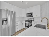 Modern kitchen featuring stainless steel appliances, white cabinets, and quartz countertops at 8416 Kawala Dr, Las Vegas, NV 89128