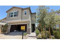 Charming two-story home featuring stone accents, an unfinished garage, and professionally landscaped front yard at 9136 Eagle Ford St, Las Vegas, NV 89113