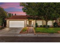 Charming single-story home featuring a red tile roof, well-manicured lawn, and inviting curb appeal at 2821 Whispering Wind Dr, Las Vegas, NV 89117