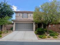 Two-story home featuring a tile roof, gray two-car garage and desert landscaping at , Las Vegas, NV 89141