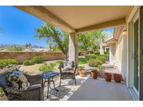 Relaxing covered patio with comfortable seating, potted plants, and a view of the landscaped backyard at 2085 Joy View Ln, Henderson, NV 89012