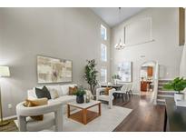 Bright and airy living room with high ceilings, modern furnishings, and dark wood flooring at 445 Colorful Rain Ave, North Las Vegas, NV 89031