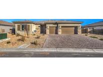 Charming single-story home with a stone-accented facade, complemented by a brick driveway and desert landscaping at 591 Jerry Bird Ct, Las Vegas, NV 89123