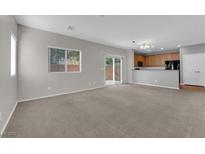 Open-concept living room with carpet and a sliding glass door to the backyard at 9024 Hazy Haven Ct, Las Vegas, NV 89149