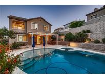 Inviting backyard pool and spa, perfect for outdoor relaxation and entertaining with covered patio and desert landscaping at 11844 Mino Rio Ave, Las Vegas, NV 89138