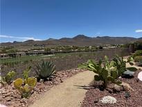 Landscaped backyard featuring desert plants, gravel pathways and views of mountains and the golf course at 18 Brookridge Dr, Henderson, NV 89052