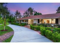 Charming single-story home with lush landscaping, a curved driveway, and a red tile roof at 200 Stonewood Ct, Las Vegas, NV 89107