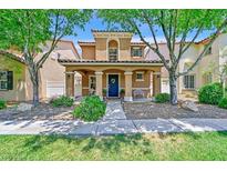 Charming two-story home featuring a cozy front porch, well-maintained landscaping, and a welcoming blue front door at 2084 Airy Petals Walk, Henderson, NV 89044
