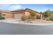 Single-story home with a tan exterior, low-maintenance landscaping, and a two-car garage at 6061 Moonlight Sonata Ave, Las Vegas, NV 89122