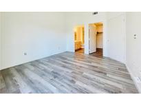 A bright bedroom with wood-look floors, ensuite bathroom, and walk-in closet provides a comfortable retreat at 1881 W Alexander Rd # 2117, North Las Vegas, NV 89032