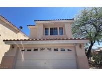 Two-story home with a two-car garage, desert landscaping, and a light beige stucco exterior at 2315 Silver Crew Pass, Henderson, NV 89052