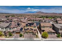 Beautiful neighborhood with mountain views, complemented by lush landscaping and solar panels on the roofs at 242 Polaris Ridge Ave, Henderson, NV 89011